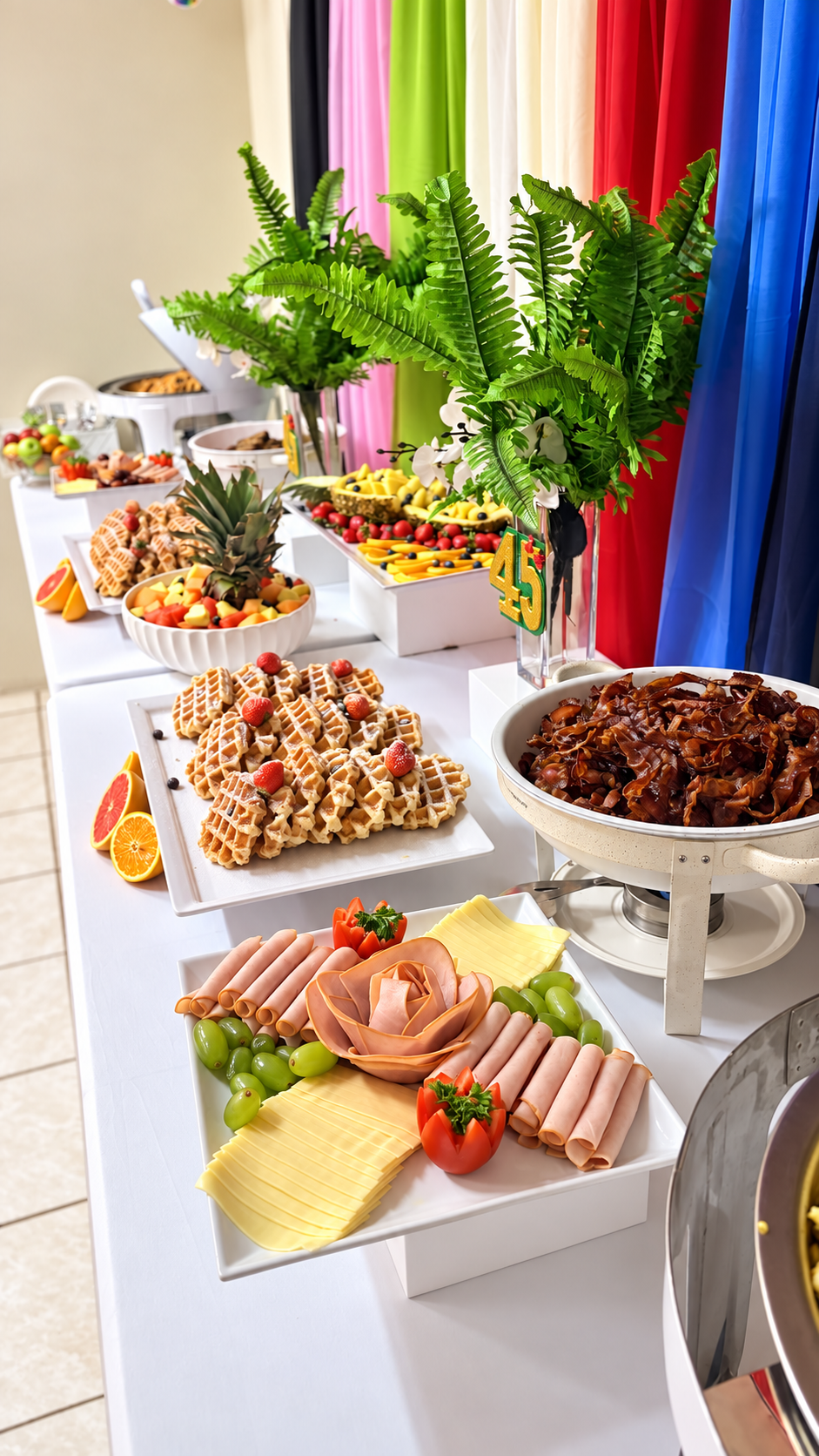 Colorful birthday brunch buffet with waffles, fruit and charcuterie