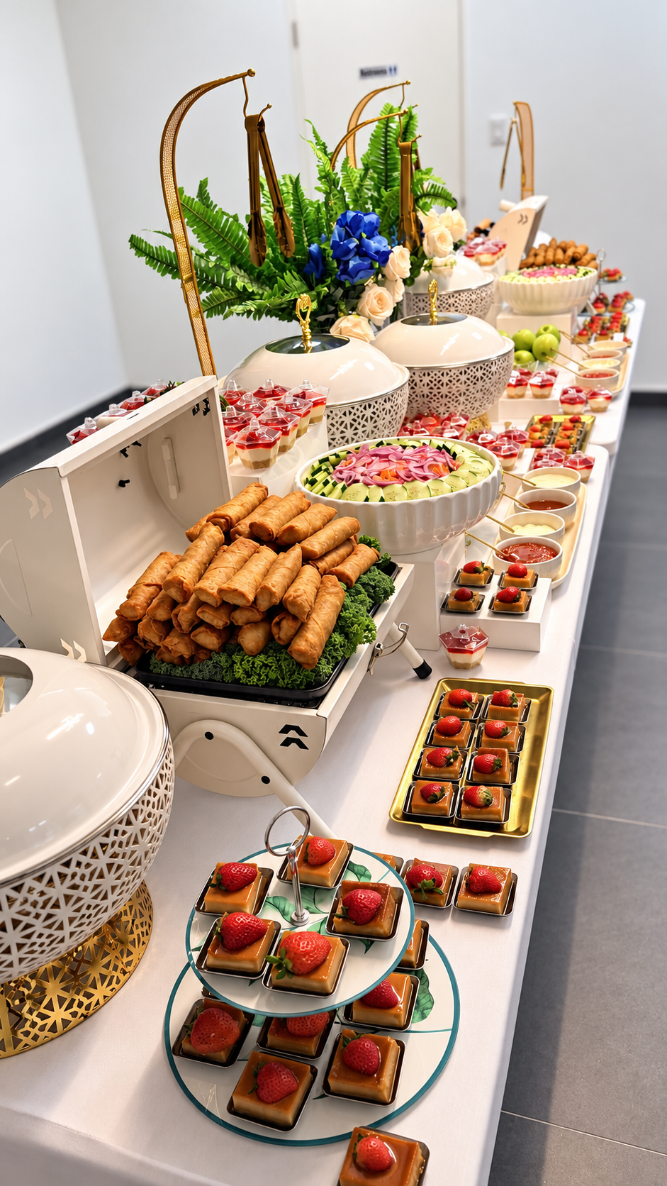 Long elegant buffet display with spring rolls, salads and petite desserts